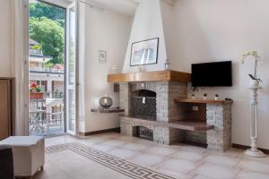 a living room with a fireplace and a tv at La Finestra sul lago 2 in Laveno-Mombello