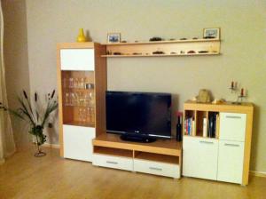 een woonkamer met een flatscreen-tv en een entertainmentcentrum bij Ferienwohnung Koriath, 15107 in Leer