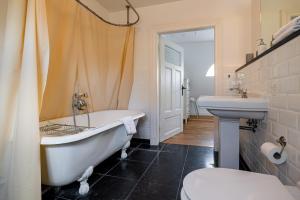 a bathroom with a tub and a toilet and a sink at Landhaus Trent Haushälfte Breetz in Trent +33 photos