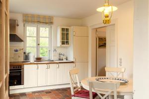a kitchen with white cabinets and a table and chairs at Landhaus Trent Haushälfte Breetz in Trent