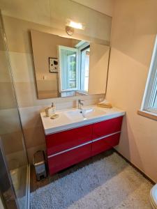 a bathroom with a red sink and a mirror at Pianoforte in Gravedona
