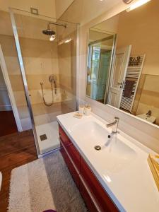 a bathroom with a sink and a shower with a mirror at Pianoforte in Gravedona +39 photos