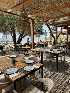 an outdoor restaurant with tables and chairs and the beach at Carvajal Beach Holiday Apartment in Benalmádena