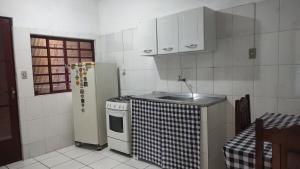 a small kitchen with a sink and a refrigerator at Casa HM in Delfim Moreira