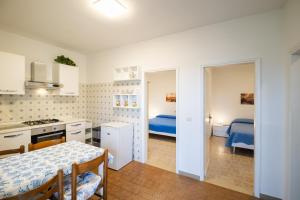 a kitchen and living room with a table and a bed at Bungalow bei Emma in Cavallino-Treporti