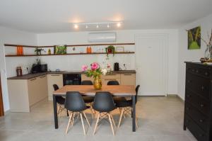 a kitchen with a table with chairs and a vase of flowers at Képes Vendégház in Tokaj