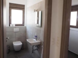 une salle de bains avec toilettes et lavabo dans l'établissement Plakopoules Beach Apartments, à Siteía 8 autres photos