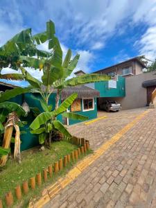 a house with a palm tree in front of it at Tropicália Chalés Boutique in Pipa +59 photos