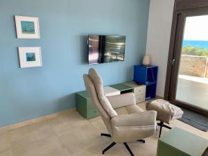 - un salon avec une chaise et un bureau dans l'établissement Plakopoules Beach Apartments, à Siteía