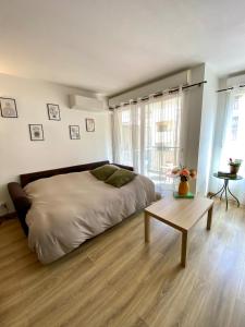 a bedroom with a large bed and a table at Le Spot Niçois in Nice