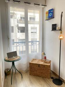 a room with a laptop on a table in front of a window at Le Spot Niçois in Nice