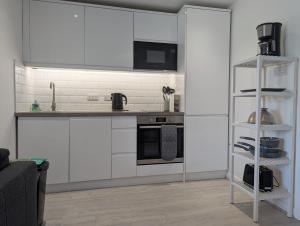 a kitchen with white cabinets and a stove top oven at Turnstone Bungalow in Hunstanton