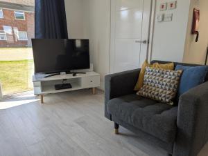 a living room with a tv and a couch at Turnstone Bungalow in Hunstanton