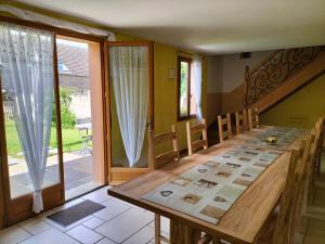 a dining room with a table and a sliding glass door at Maison d'Othe in Saint-Mards-en-Othe