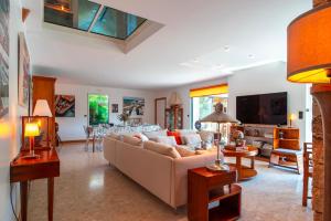 a living room with a couch and a tv at L'Oasis Bretonne - Charmante maison avec piscine in La Trinité-sur-Mer