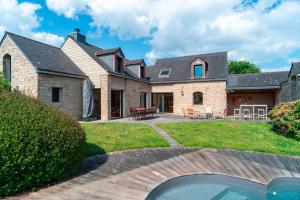 an exterior view of a house with a patio at L'Oasis Bretonne - Charmante maison avec piscine in La Trinité-sur-Mer
