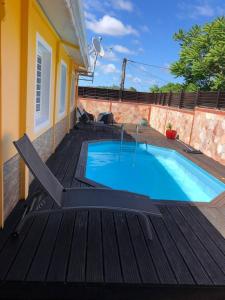 una piscina sulla parte superiore di una terrazza in legno di Villa spacieuse avec piscine à Le Marin a Le Marin
