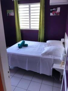 una camera da letto con un letto bianco e una finestra di Villa spacieuse avec piscine à Le Marin a Le Marin Altre 9 foto