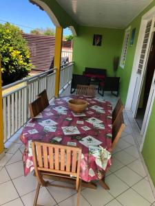 un balcone con tavolo e sedie sul portico di Villa spacieuse avec piscine à Le Marin a Le Marin