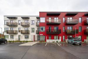 a red and white apartment building with a parking lot at Kristalli 8-2 apartment in Tartu