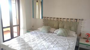 a bedroom with a large bed with two pillows at Casa Maggy in Budoni