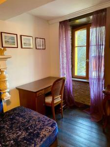 a bedroom with a desk and a window at La maison d'en haut in Josselin +4 photos