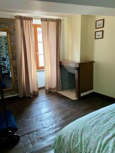 een slaapkamer met een bed, een bureau en een raam bij La maison d'en haut in Josselin +3 foto's