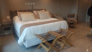 a bedroom with a large bed and a wooden stool at Blizu in Villa La Angostura