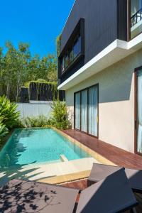 a swimming pool in front of a house at Modern 3 Bdr Villa Tree O'Clock Bangtao With a Pool in Ban Pak Lak