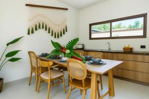 a dining room with a table and chairs at Modern 3 Bdr Villa Tree O'Clock Bangtao With a Pool in Ban Pak Lak