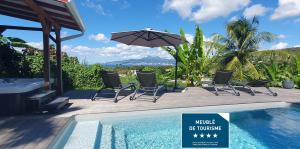 莱特鲁瓦西莱Villa KANOA - T2- classé 4 étoiles - Vue Mer - Piscine - SPA的游泳池旁带椅子和遮阳伞的天井
