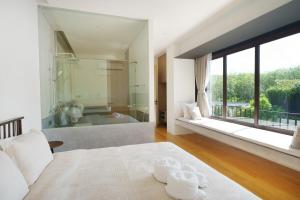 a bedroom with a large window and a bath tub at Modern 3 Bdr Villa Tree O'Clock Bangtao With a Pool in Ban Pak Lak +32 photos