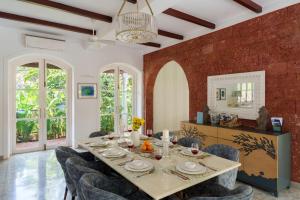 a dining room with a table and chairs at La Pasado, Huge 4 BHK villa with Large Private Pool & Garden, in Assagao, Complimentary Breakfast, full time caretaker, Bathtub, ideal for large groups in Assagao