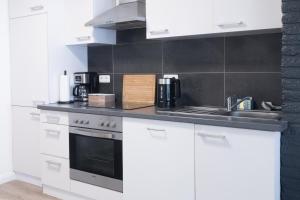 a white kitchen with a sink and a stove at Apartment in Lüneburg, 2 Zimmer, Küche, 80 qm in Lüneburg
