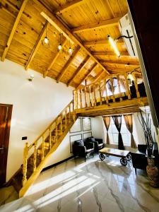 a living room with wooden ceilings and a staircase at Republika Central Hotel & Resort in Abbottabad