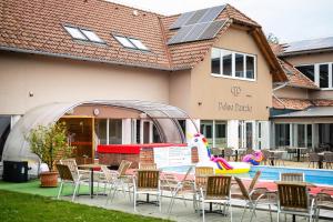 a pool with chairs and a table and a swimming pool at Pelso Panzio in Balatonmáriafürdő