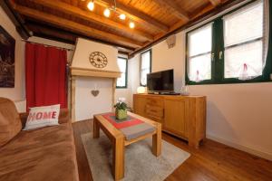 a living room with a couch and a tv at Urlaub im historischen Pesthäuschen in Xanten +4 photos