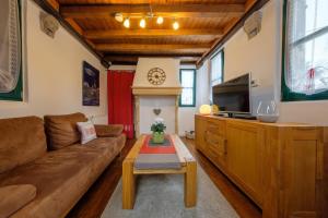 a living room with a couch and a tv at Urlaub im historischen Pesthäuschen in Xanten