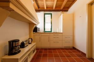 a kitchen with white cabinets and a tile floor at Urlaub im historischen Pesthäuschen in Xanten