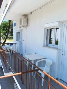 a balcony with chairs and tables and a window at Ξενοδοχείο ΑΡΓΩ in Myrina