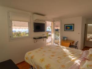 a bedroom with a bed and a window and a television at Charmant studio rénové avec terrasse, climatisation et WiFi gratuit - FR-1-196-166 in Menton