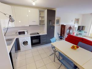 une cuisine avec une table et un canapé rouge dans l'établissement Spacieux 3P en Centre-ville de Menton, Terrasse, Parking, Wifi Gratuit, Proche Plage - FR-1-196-270, à Menton 8 autres photos