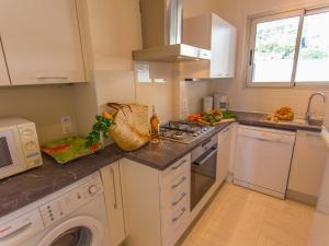 a kitchen with a stove top oven next to a microwave at Superbe 2P climatisé avec terrasses, garage et piscine, face à la mer. - FR-1-196-222 in Menton