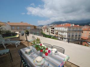 a table on a balcony with a view of a city at Charmant 2P en Centre-Ville de Menton avec Terrasse et Parking - FR-1-196-280 in Menton