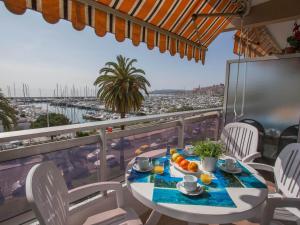 a table on a balcony with a view of a harbor at Studio rénové face mer avec terrasse, clim, wifi et proche commodités à Menton - FR-1-196-167 in Menton