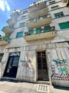 a building with graffiti on the side of it at Casa Fiocchetto - Giardini Reali in Turin