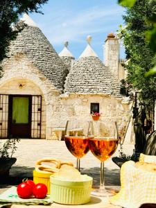 dos copas de vino sentadas en una mesa frente a un edificio en Trulli Pietra Viva, en Alberobello