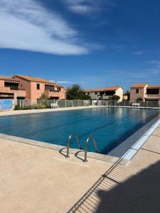 Una gran piscina con agua azul en un edificio. en studio village naturiste, en Leucate