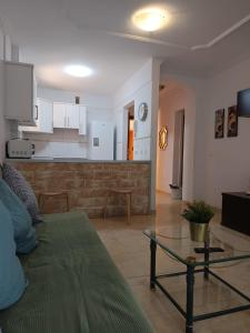 a living room with a couch and a kitchen at alquilaencanarias Candelaria, Terrace and Pool ! in Candelaria