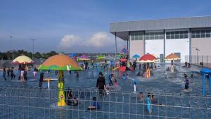 a group of people in a water park with umbrellas at Cozystayz NuNa in Sitiawan